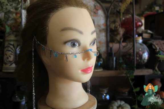 Bijou de front chaine argentee avec perles bleues, porte sur buste