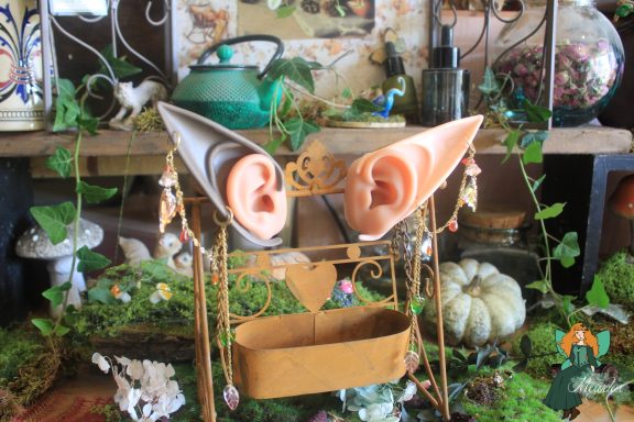 Paire de bijoux d'oreille elfiques presentee sur presentoir a oreilles